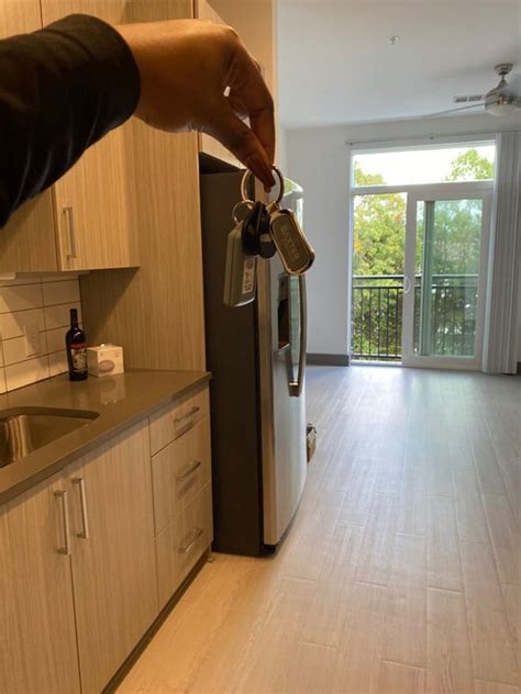 A Person Is Pouring Coffee Into A Mug In A Kitchen With White Cabinets