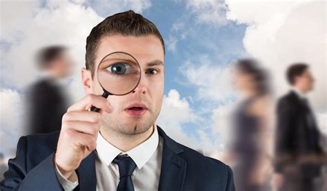 Premium Photo Businessman Looking Through Magnifying Glass Against Blue Sky With White Clouds