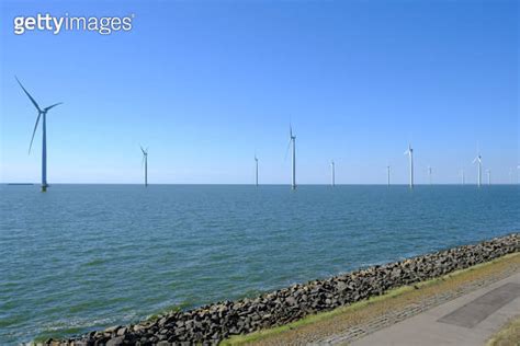 Wind Turbines In A Windpark On The Shore Of A Lake In The Netherlands