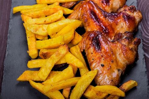 Asas De Frango Frito E Batatas Fritas Em Um Prato Preto Fundo De