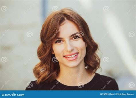 Portrait Of A Beautiful Young Woman With Long Brown Hair Smiling At The