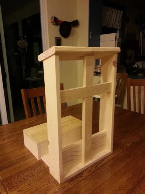 An Unfinished Dollhouse Sitting On Top Of A Wooden Table Next To A