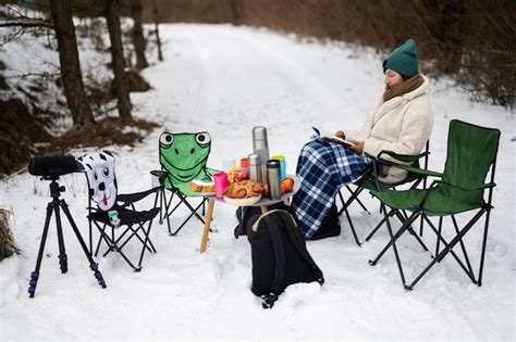 Premium Photo Woman Sit In Chair And Read Book In Winter Forest On A