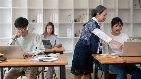 An Experienced Mature Asian Female Teacher Or Professor Teaching Students In The Classroom Stock