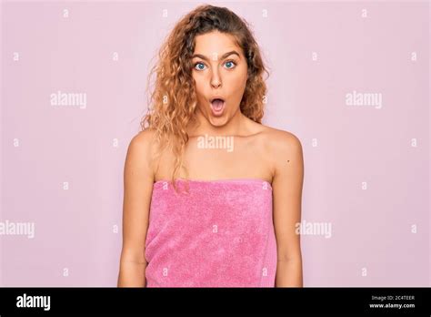 Beautiful Blonde Woman With Blue Eyes Wearing Towel Shower After Bath Over Pink Background
