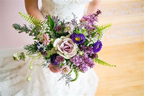 A Bride Holding A Purple And White Bouquet