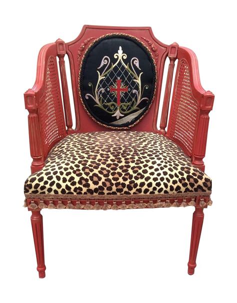 A Red Chair With Leopard Print Upholstered On It S Seat And Back