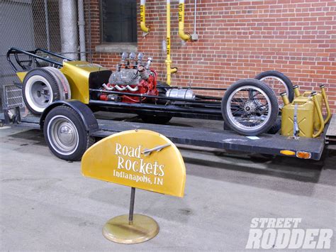 An Old Yellow Car Is On Display At The Street Rodder Museum