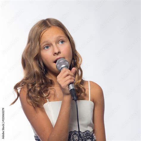 Emotional Blonde Girl In A White Dress Singing Into A Microphone On A