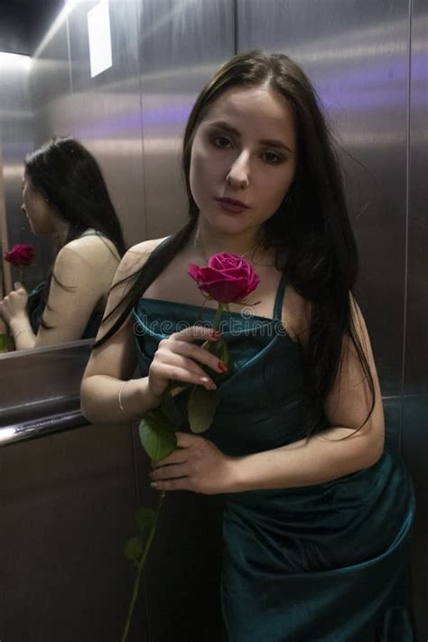 Confident Brunette Woman In Elegant Aquamarine Colored Dress With Red