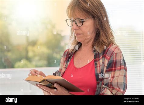 Mature Woman Reading A Book At Home Light Effect Stock Photo Alamy