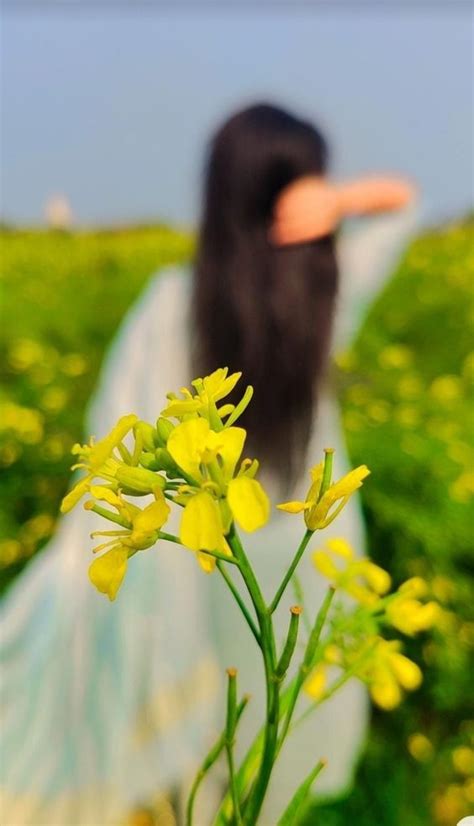 A Woman With Long Black Hair Is Standing In A Field Full Of Yellow