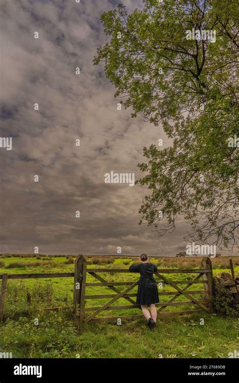 Girl Stood Leaning Against 5 Bar Gate Contemplating Life In The Countryside At Osmotherly North