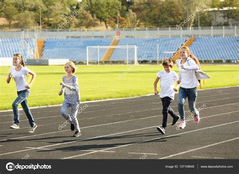 Sporty Children Running Track Stadium Stock Photo by ©belchonock 137108648