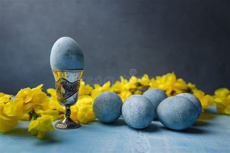 Blue Painted Egg In Silver Egg Cup Easter Eggs And Yellow Flowers On