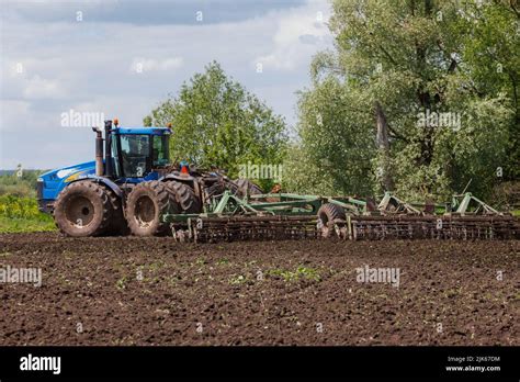 Blue Tractor With Double Wheels Pulling Disc Harrow With Roller Basket