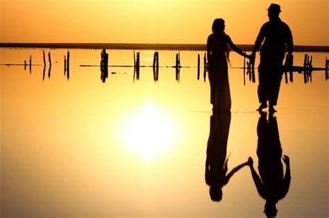 Una Pareja Feliz En El Mar Con Fondo De Silueta De Reflejo De Agua