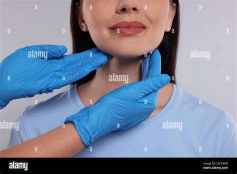 Endocrinologist Examining Thyroid Gland Of Patient On Light Grey