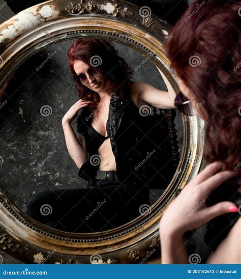 Beautiful Young Woman Looking On Her Reflection At The Mirror Stock