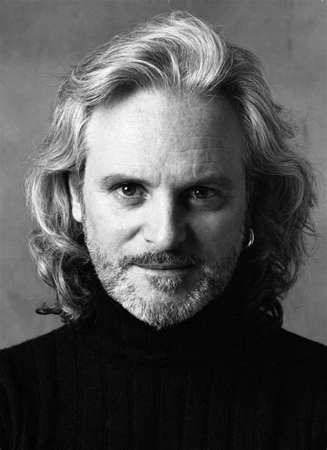 A Black And White Photo Of A Man With Long Hair Wearing A Turtle Neck