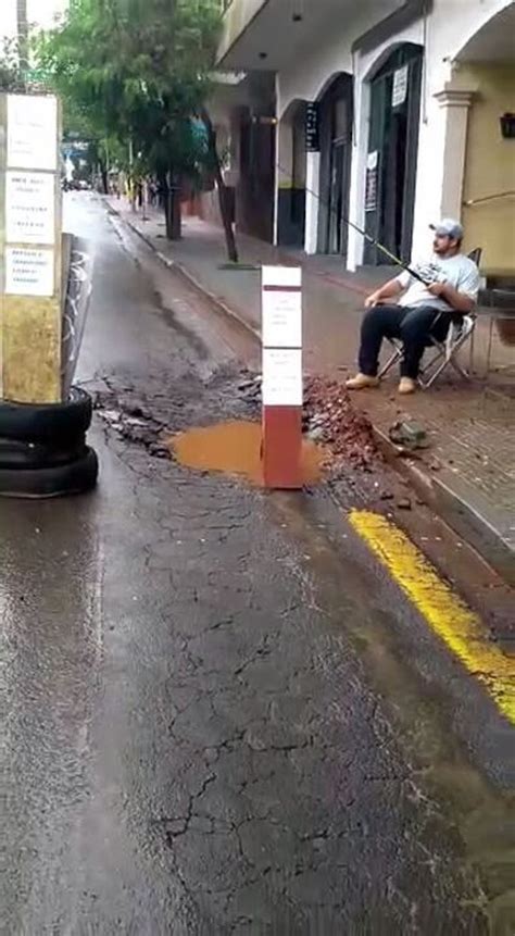 Em protesto comerciante pesca em buraco de rua na região central de