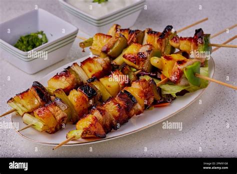 Traditional Pork And Pineapple Kebabs On Sticks With A Sauce At The