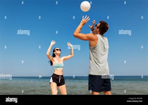 Pareja feliz jugando voleibol de playa de verano Fotografía de stock