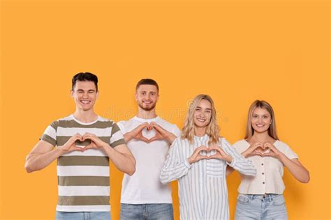 Happy Volunteers Making Hearts with Their Hands on Orange Background ...