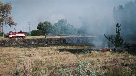 Firefighter Battling A Wild Blaze Amidst Flames And Smoke During A