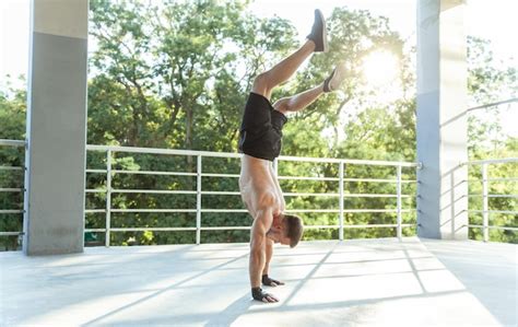 Premium Photo Muscular Man With A Naked Torso Walks On His Hands Head Down Outdoors Functional