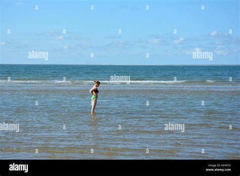 Mädchen im Bikini steht an der Seite in das Wasser in der Nordsee Stockfotografie Alamy