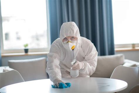 Mujer Con Ropa De Trabajo Blanca Y Guantes Protectores Limpiando La