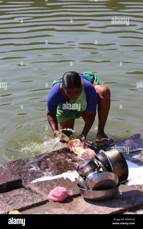 Indian Woman Washing Clothes And Dishes On The River Inderin Beim