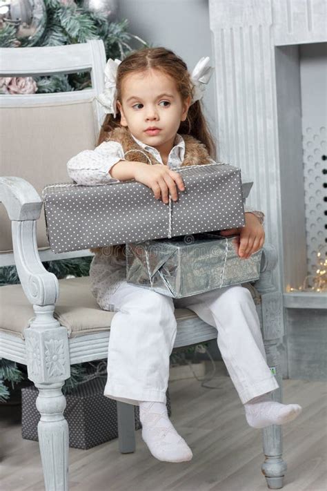 Little Kid Girl Sitting in Chair with Christmas Gift Box. Stock Image ...