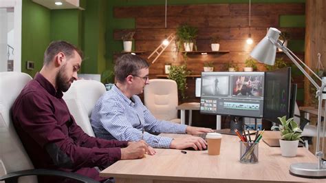 Team of film editors in the office talking about their last media