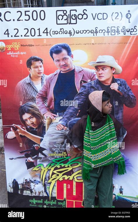 Local boy standing in front of a movie poster in centre of Yangon ...