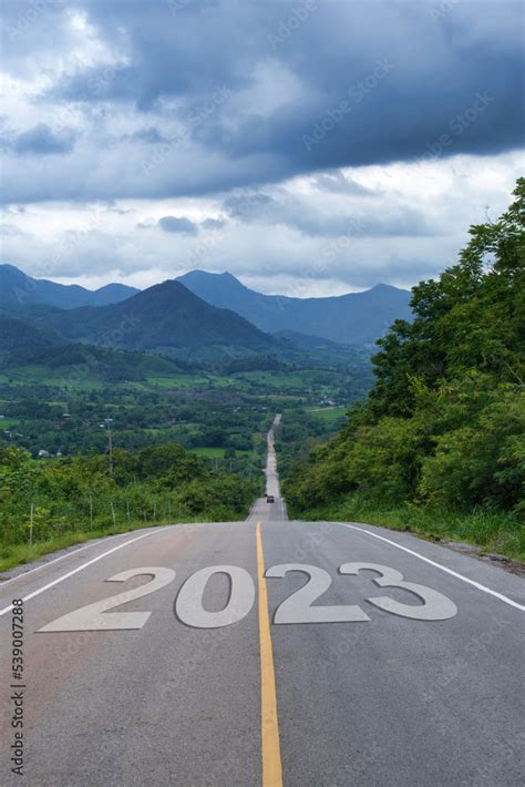 Country road leading to mountains numbered 2023. 2023 start concept ...