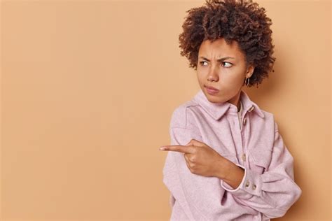 La toma horizontal de una joven disgustada y enfurruñada señala con el