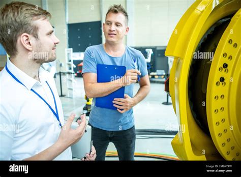 Engineers inspect industrial robot Stock Photo - Alamy