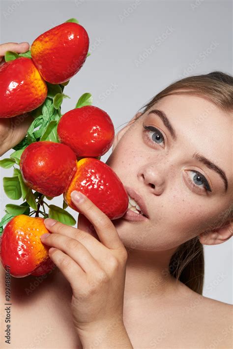 Close Up Portrait Of A Blond Girl With Naked Shoulders She Holding Bunch Of Mangoes Near Her