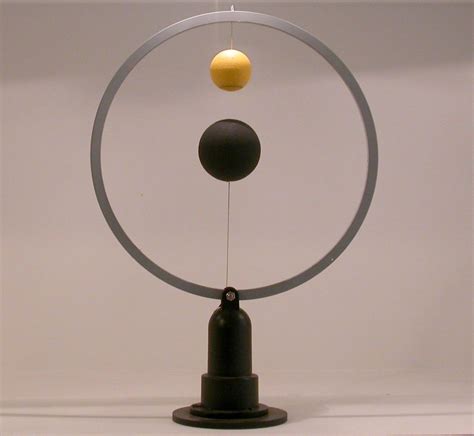 an object with two balls attached to it's sides in front of a white ...