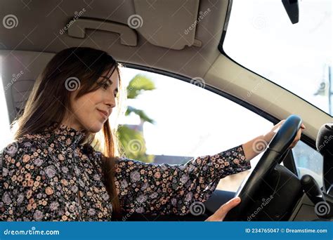 Jovencita De Brunette Segura Y Feliz Conduciendo En Auto Imagen De Archivo Imagen De Sunlight