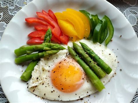 Primer plano de huevos fritos con verduras como espárragos rebanada de