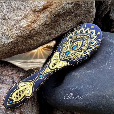 A Blue And Gold Colored Hair Brush Sitting On Top Of A Rock