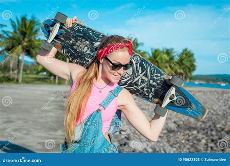 相当与longboard的性感的少妇在晴朗的天气的立场在海前面和棕榈 滑稽的微笑的女性 休闲 库存图片 图片 包括有 喜悦 快乐