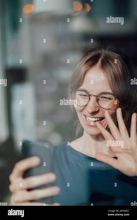 Happy Businesswoman Waving Hand While Doing Video Call Through Smart