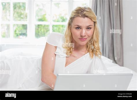 Pretty Blonde Lying On Bed Using Laptop Smiling At Camera Stock Photo Alamy