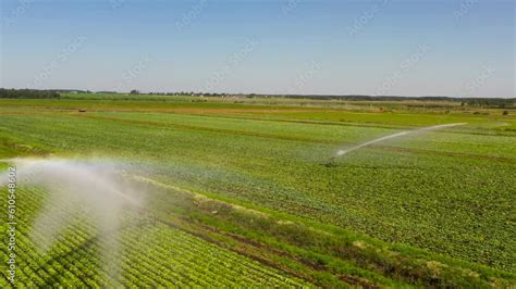 Irrigation of farmland with a tractor irrigation system from above. An ...