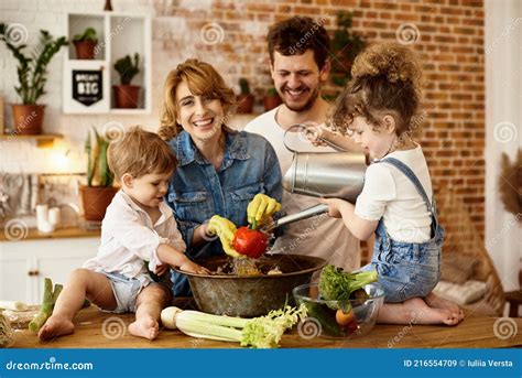 Familia Feliz Con Sus Hijos Cocinando En La Cocina Imagen De Archivo