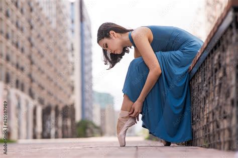 Beautiful Asian Ballerina In Blue Dress Adjusting Her Pointe Shoes